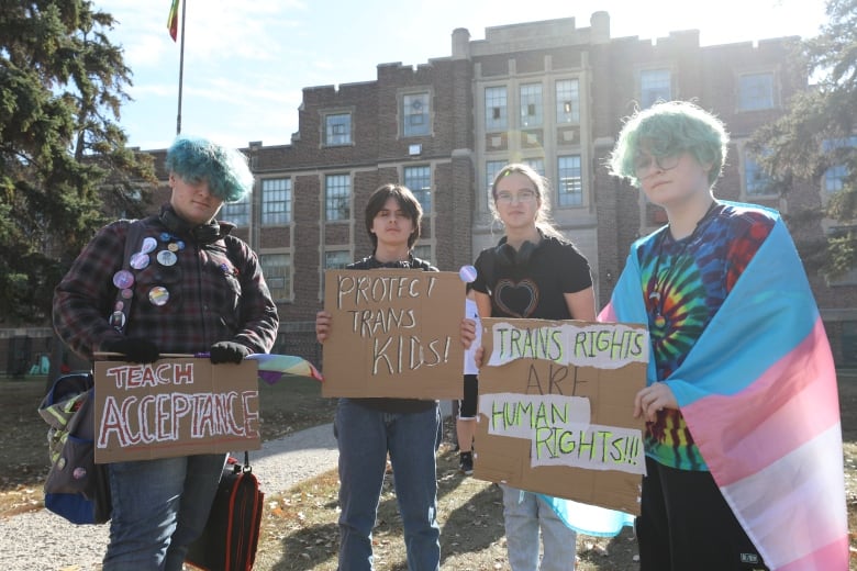 Youths hold signs calling for the protection of trans kids and their rights. 