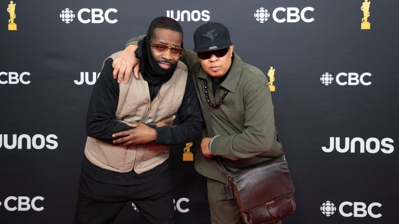 Dream Warriors pose on the red carpet at the Juno Awards wearing a beige vest and olive green jacket.