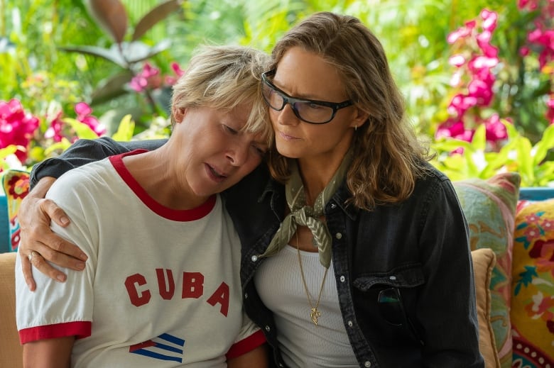 Still frame from the film Nyad. Jodie Foster and Annette Bening lean in to one another, both looking worried.