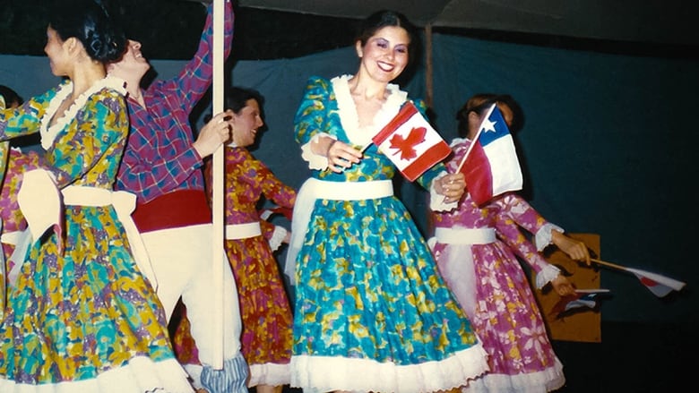 Canadian woman pictured Chilean dancing while holding little flags of Canada and Chile.