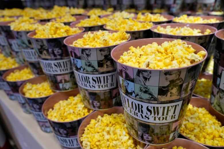 Filled popcorn containers are seen stacked.